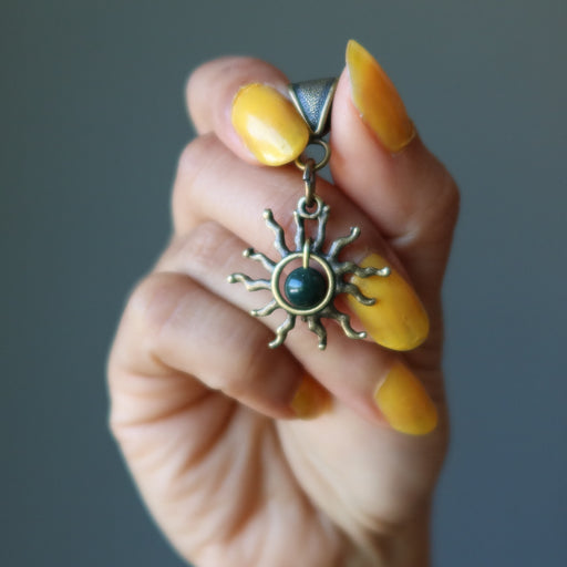 hand holding bloodstone sun pendant