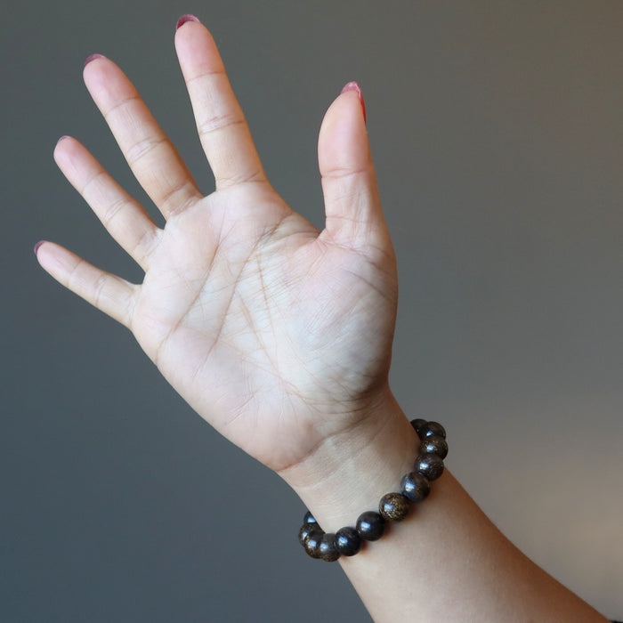 hand wearing a bronzite bracelet