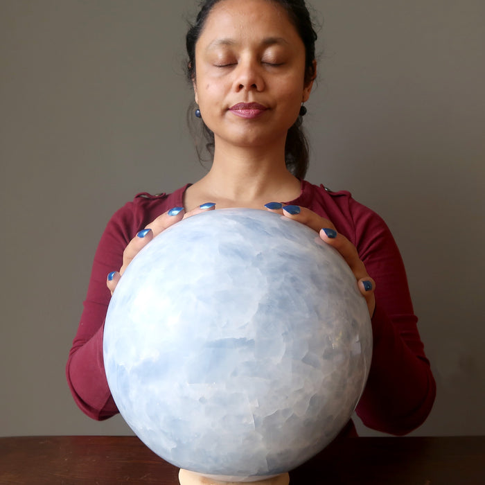 sheila of satin crystals meditating on extra large Blue Calcite sphere