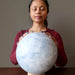 sheila of satin crystals meditating on extra large Blue Calcite sphere