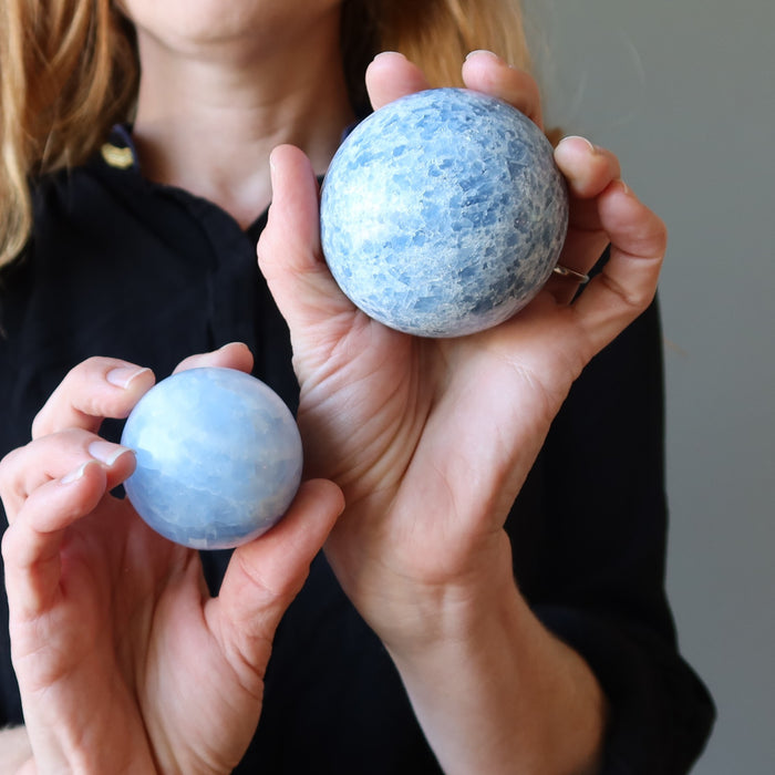 female model holding a Blue Calcite sphere on each hand