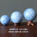 three diffeent size blue calcite spheres on the wooden stands