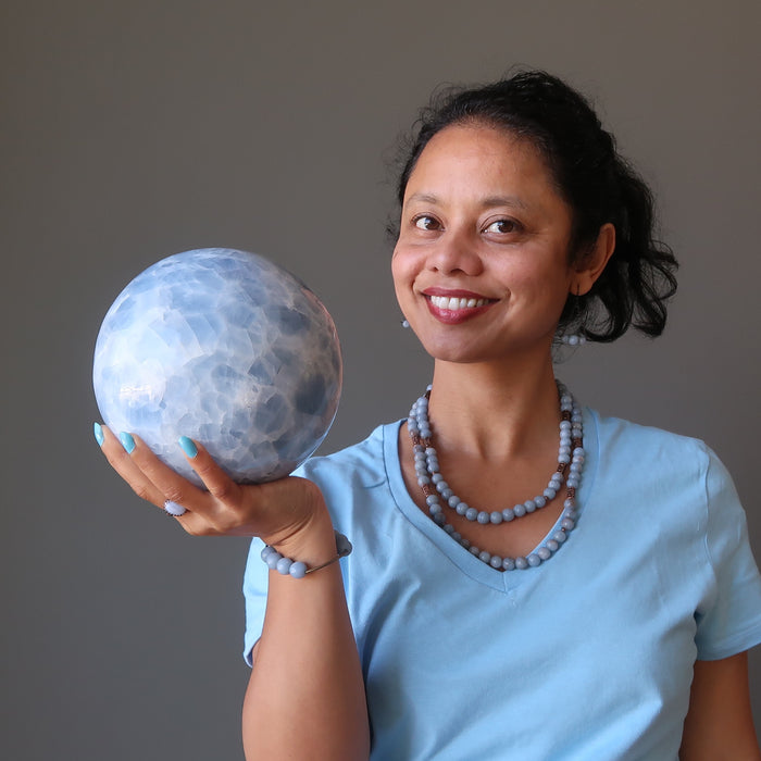 sheila of satin crystals holding extra large blue calcite ball
