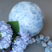 extra large blue clacite sphee with raw blue calcite stones and blue flowers