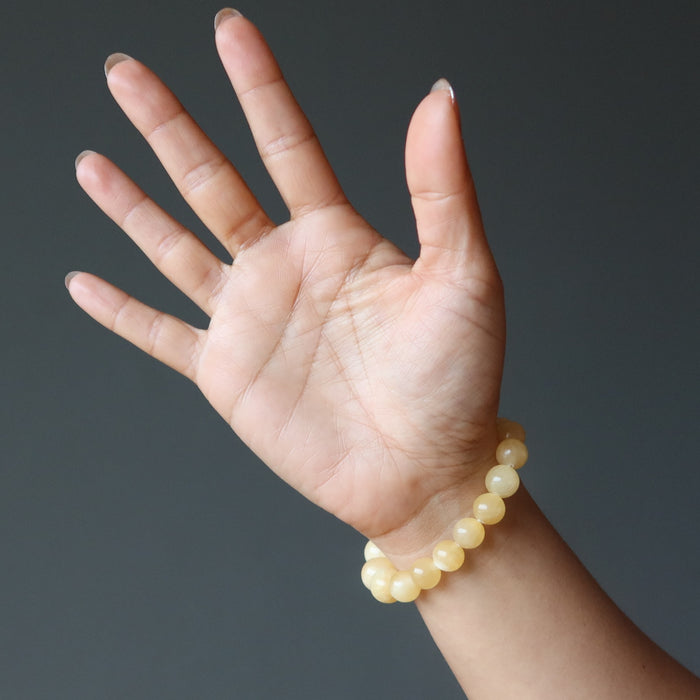 hand wearing a yellow calcite beaded stretch bracelet