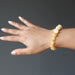 hand wearing a yellow calcite beaded stretch bracelet