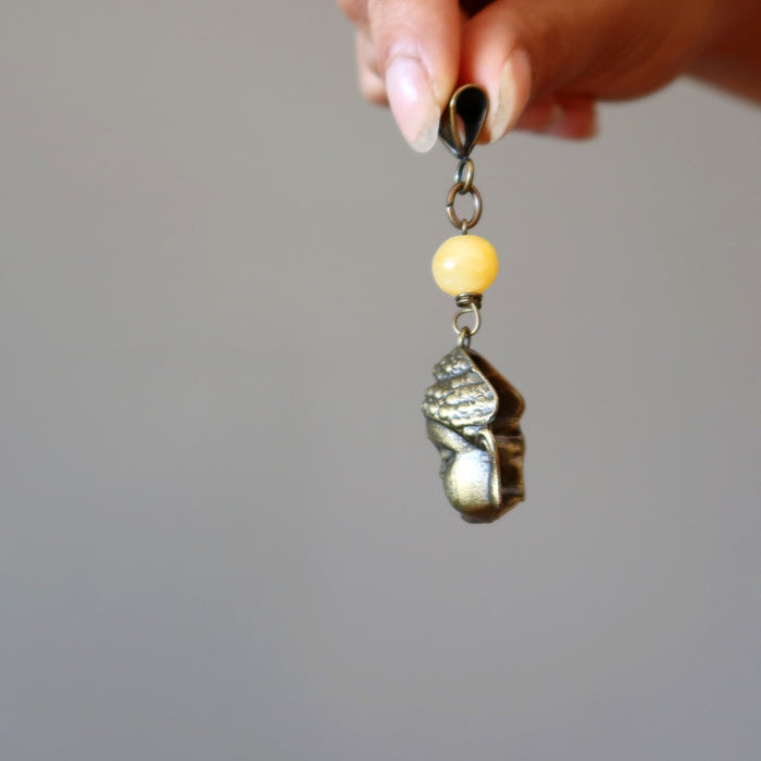 holding Yellow Calcite bead and brass Buddha Pendant 