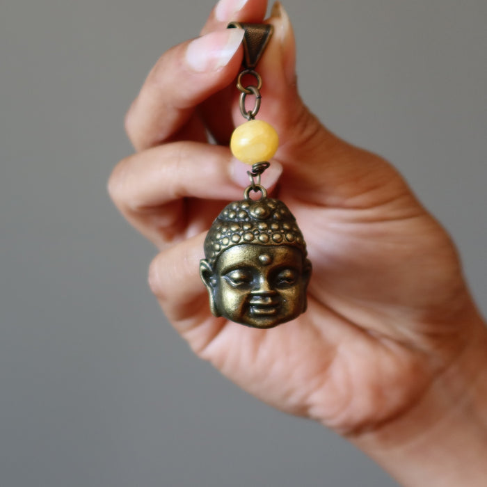 holding Yellow Calcite bead and brass Buddha Pendant 