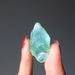 hand holding green calcite rough stone