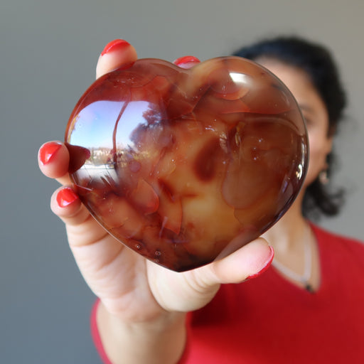 sheila of satin crystals holding orange carnelian heart