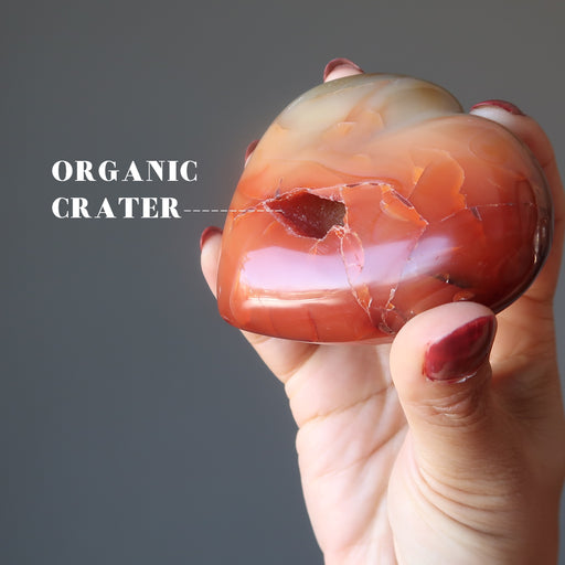 holding Orange Carnelian Heart showing organic crater