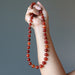 hand holding carnelian copper beaded necklace