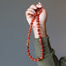 hand holding carnelian copper beaded necklace