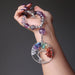 hand holding the rainbow fluorite chakra tree of life necklace