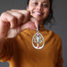 woman holding chakra tree of life pendant