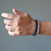 female hand modeling faceted gray and brown chalcedony beaded stretch bracelet set