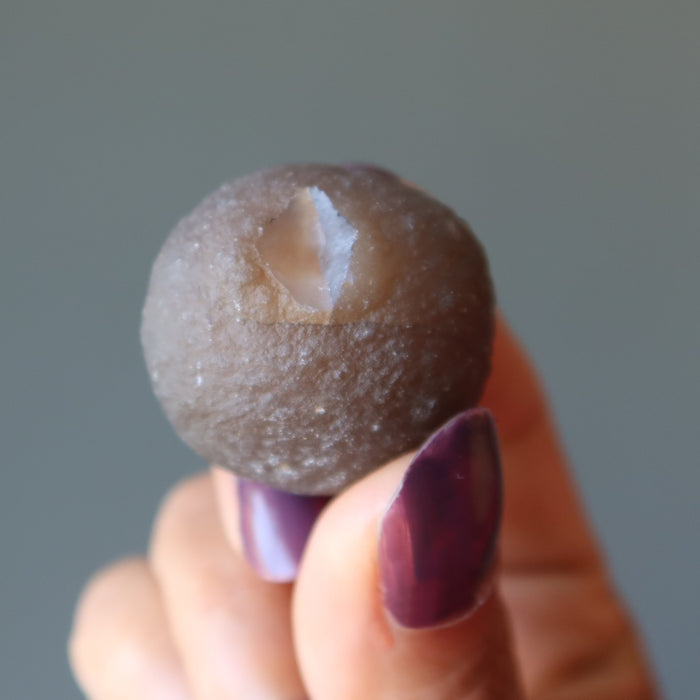 holding one Brown Raw Chalcedony Gemstone showing crater