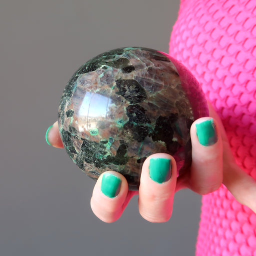 female hand holding chalcocite sphere
