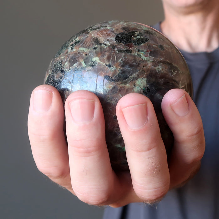 male hand holding chalcocite sphere