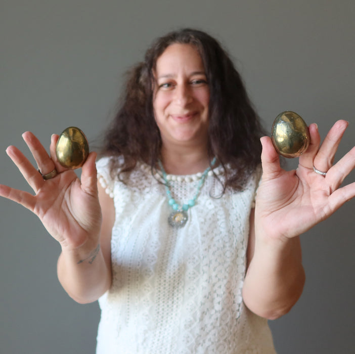 female model holding two chalcopyrite eggs