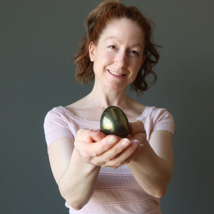 female model holding chalcopyrite egg
