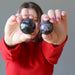 female model raising arms with two Purple Charoite Sphere on each hand