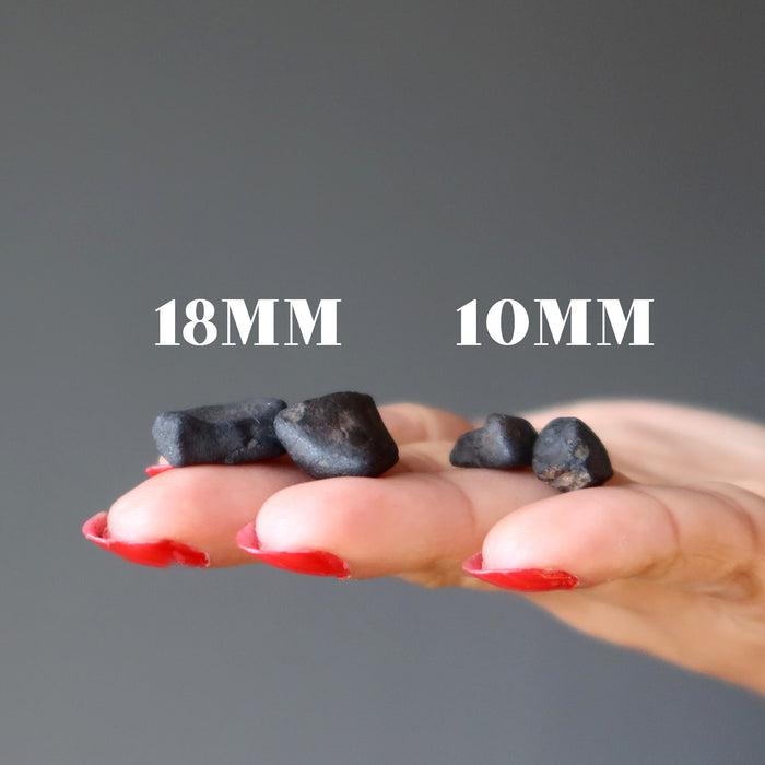 hand holding two pairs of chelyabinsk meteorites in 18mm and 10mm
