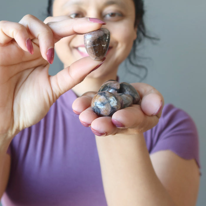 sheila of satin crystals displaying Chiastolite Tumbled Stone Set on her palm