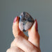 fingers holding Chiastolite Tumbled Stone