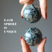hands holding Green Tourmaline Spheres one on each hand