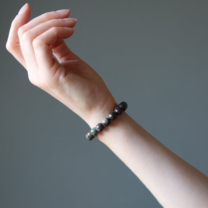 female hand model wearing chrysocolla cuprite bracelets