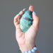 hand holding blue-green and black chrysocolla oval cabochon