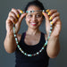 sheila of satin crystals holding a chrysoprase beaded necklace
