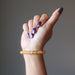 female hand modeling yellow citrine beaded stretch bracelet 