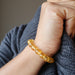 female hand modeling yellow citrine beaded stretch bracelet 