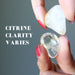 hands holding two citrine showing clarity varies