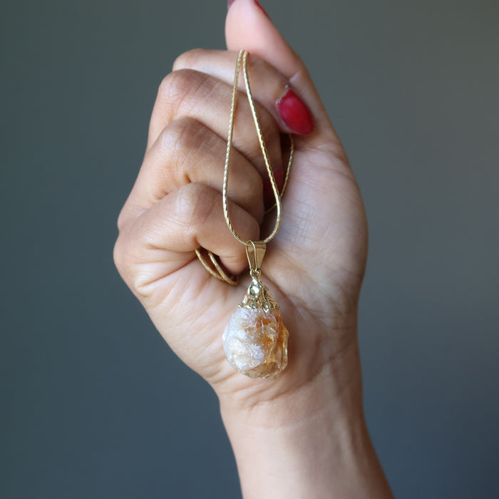 hand holding raw citrine necklace