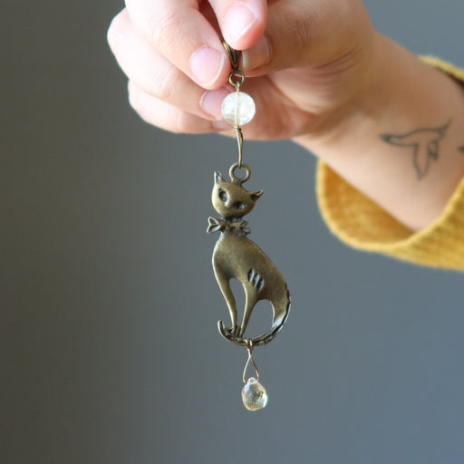 holding brass feline hangs with faceted yellow Citrine drops from a polished Citrine orb on a long pendant
