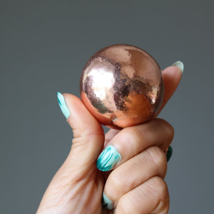 hand holding a copper alchemist sphere