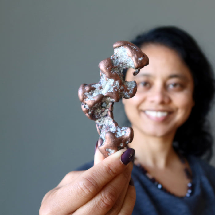 sheila of satin crystals holding Raw Copper Gemstone 