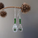 displaying sterling silver cat and green diopside gemstone earrings on the dry branch