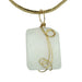 wavy rectangle white Dolomite stone wrapped in gold plated wire pendant hangs on Gold plated choker 