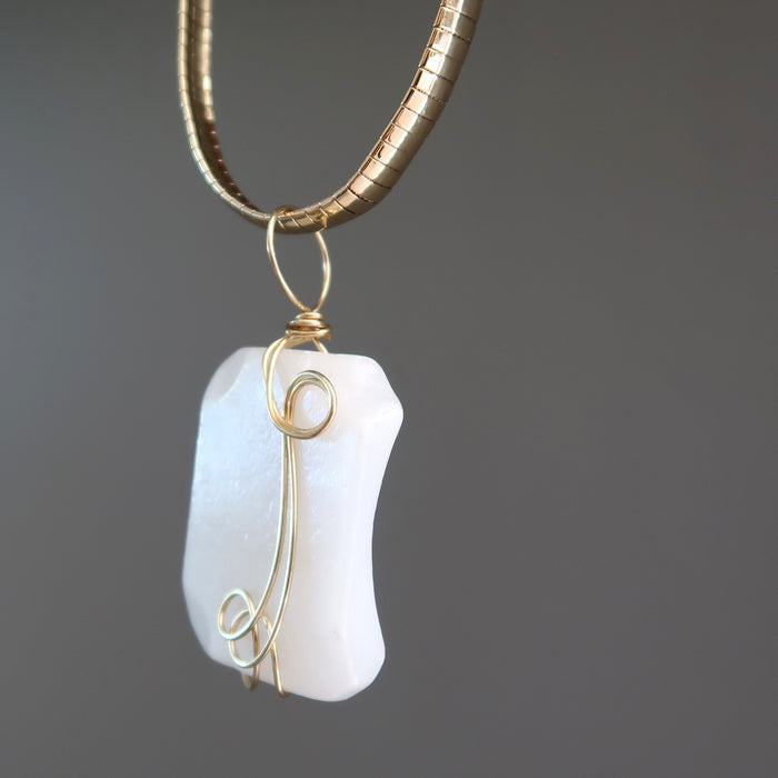 wavy rectangle white Dolomite stone wrapped in gold plated wire pendant hangs on Gold plated choker
