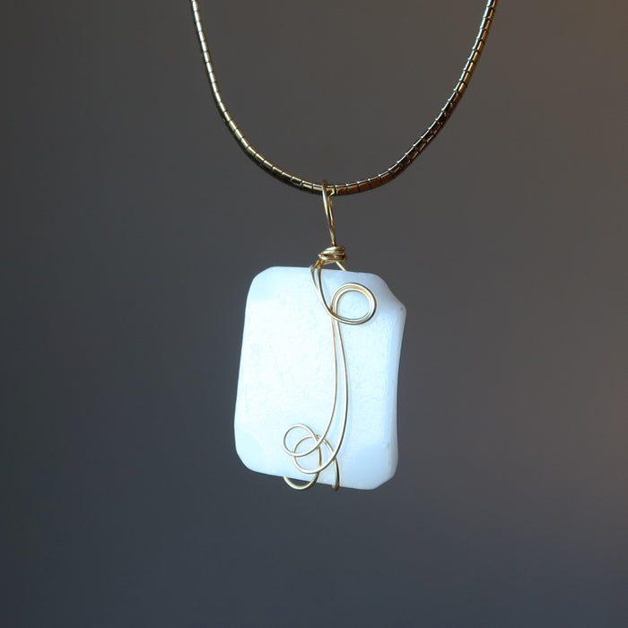 wavy rectangle white Dolomite stone wrapped in gold plated wire pendant hangs on Gold plated choker