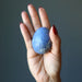 hand holding blue dumortierite crystal egg
