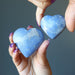 hands holding two dumortierite crystal heart