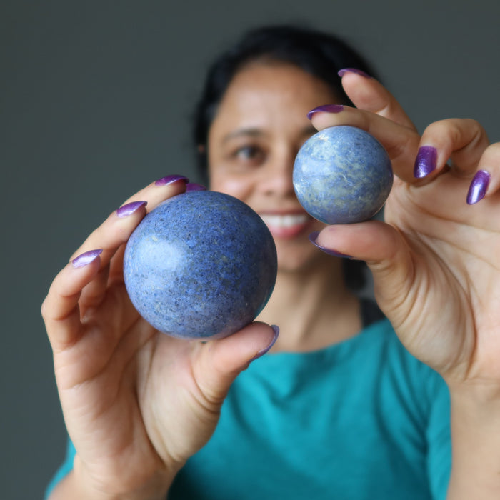sheila of satin crystals holding blue Dumortierite Sphere on both hands