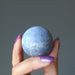 hand holding blue Dumortierite Sphere