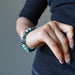 female hand on hip modeling polished emerald stretch bracelet