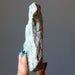 hand holding rough green epidote standing mineral stone